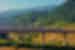 Bullet train on high rail line passing through the mountain backed agricultural landscape of Yunnan Province China