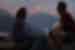 Two travellers look out from a lodge as sunrise hits a mountain in Annapurna morning in Nepal
