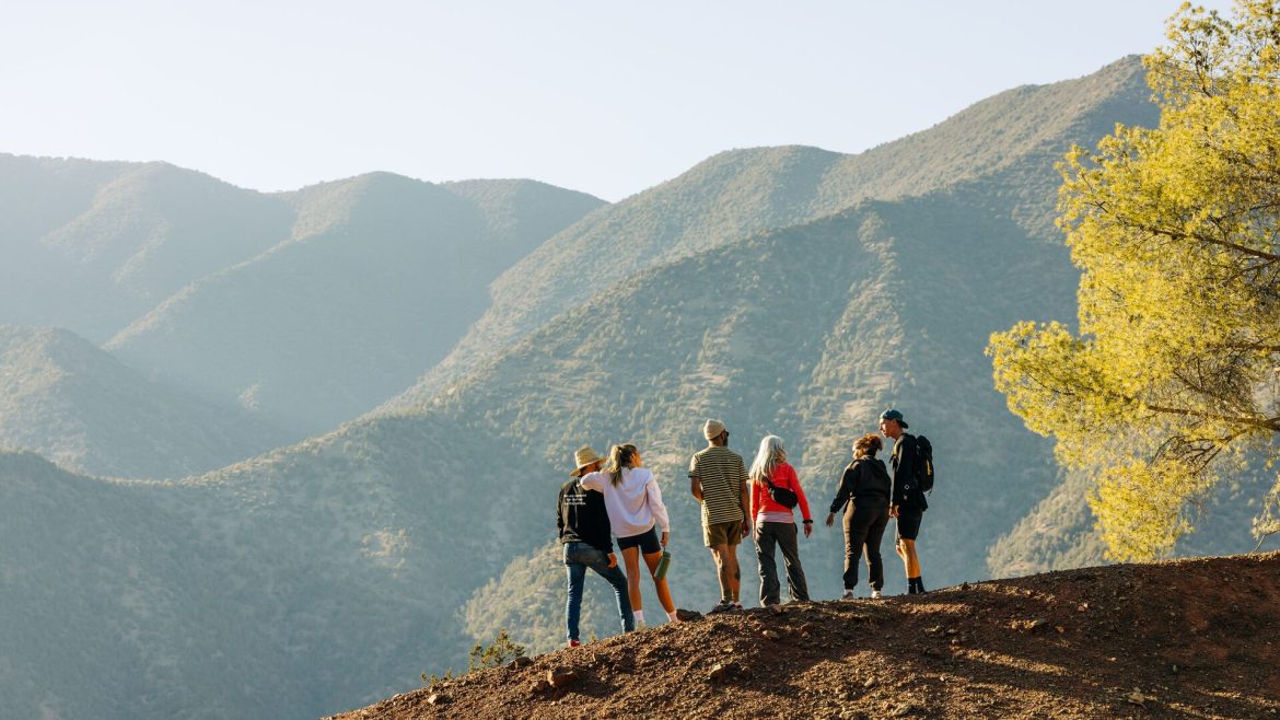 A group of travellers standing on a scenic ridge while trekking in Ouirgane, Morocco