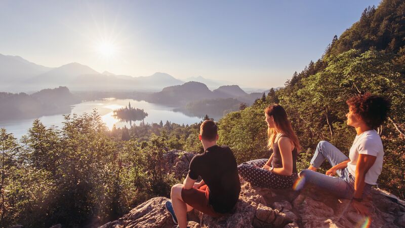  Viajantes sentados em cima de uma rocha na Eslovénia. 