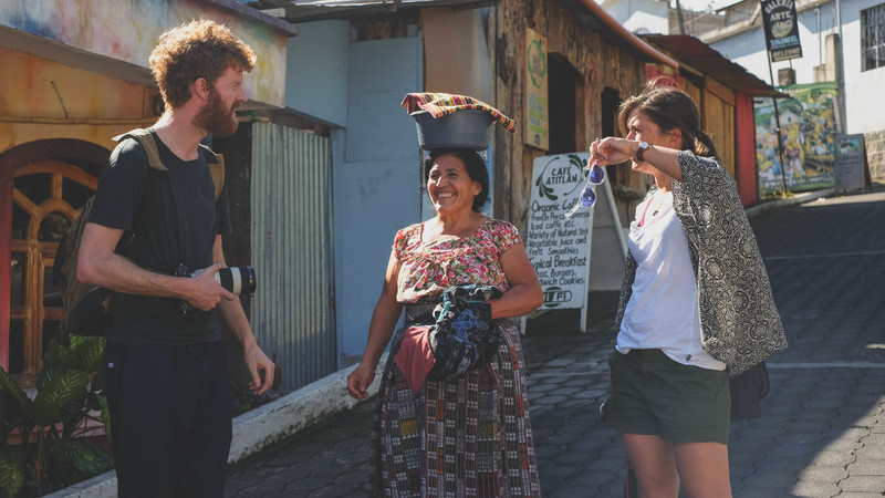 Two travellers meet a local woman in Guatemala