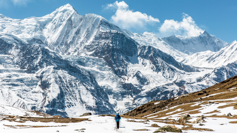 A hiker in front of the Annapurna Mountains on the Annapurna Circuit trek