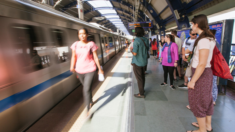 Train arriving at a busy platform with travellers waiting to board