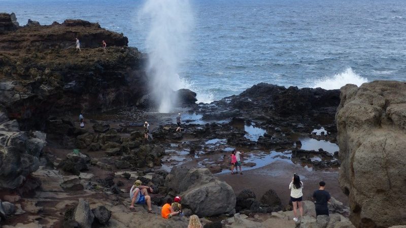 Travellers exploring a blowhole in Hawaii