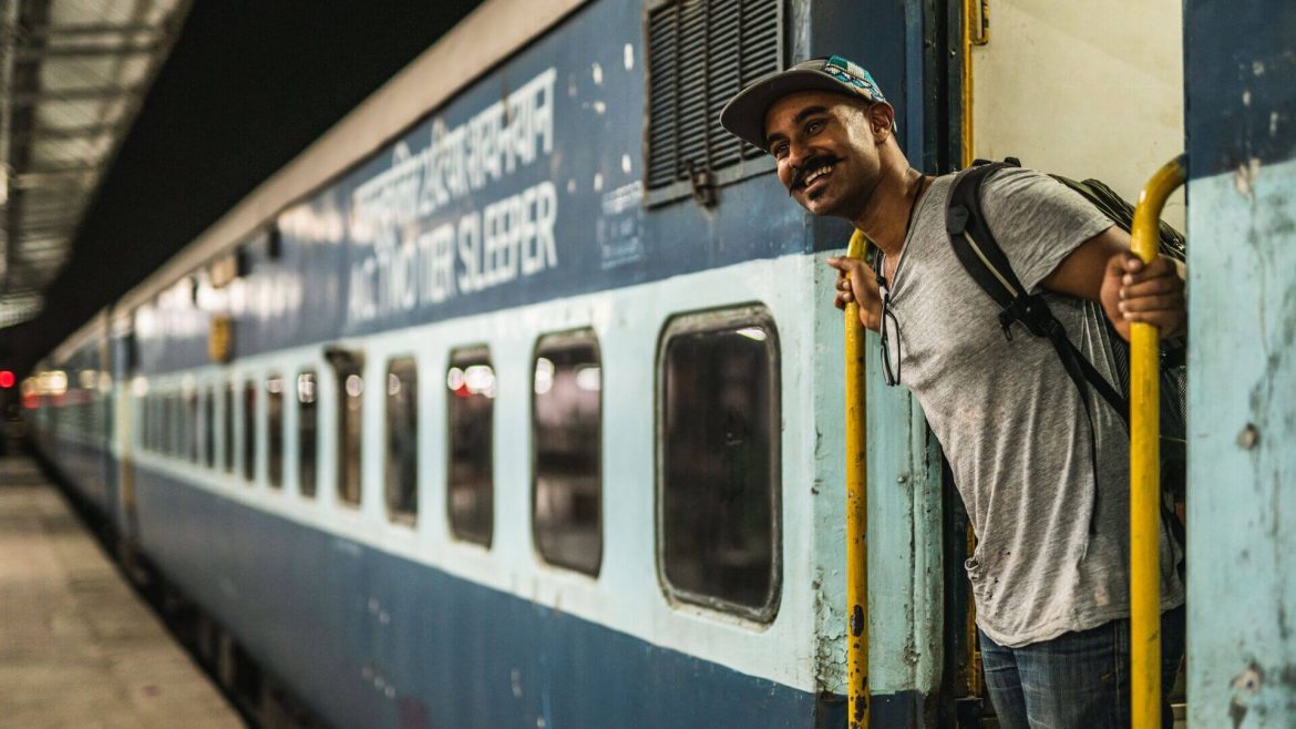 Passenger smiling from train car, India