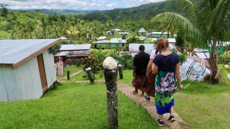 Travellers walk through a homesetay in Fiji