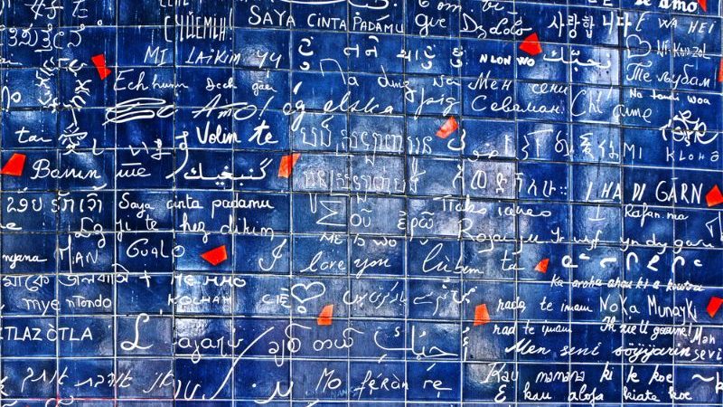 Blue tiled wall covered in graffiti