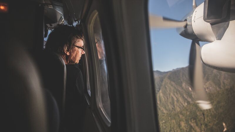 A man looking out the window of a small plane in Nepal