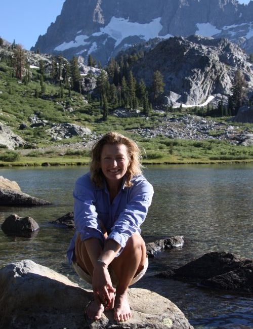 A woman sitting near a lake in Sierra Nevada