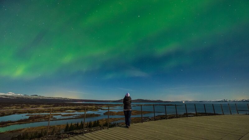 A traveller looking at the northern lights in iceland