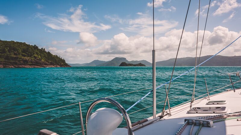 A sailing boat cruising past some Whitsunday islands 