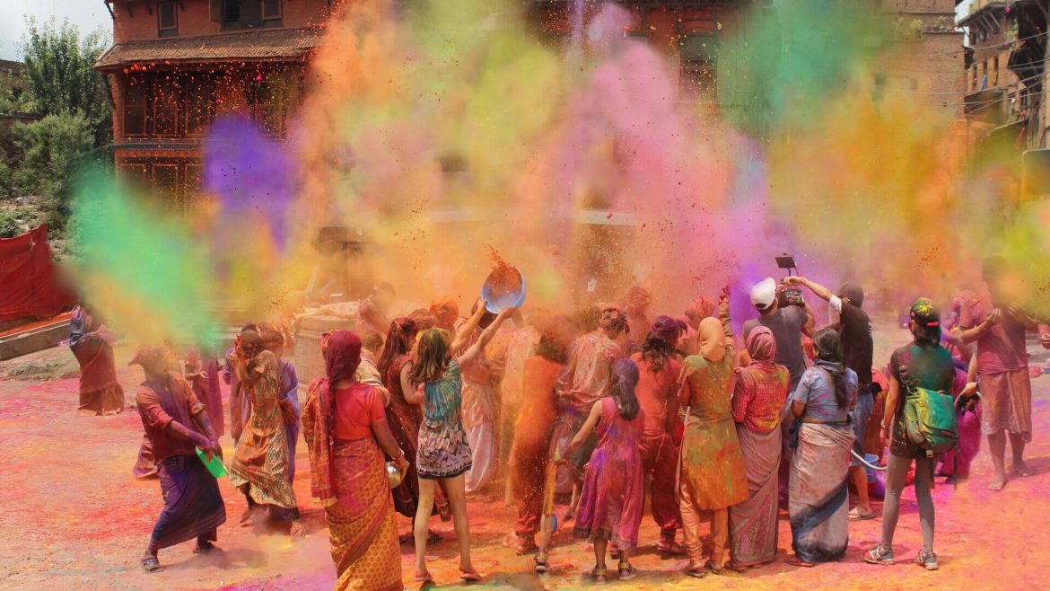 Holi celebrators throw coloured powder into the air, India