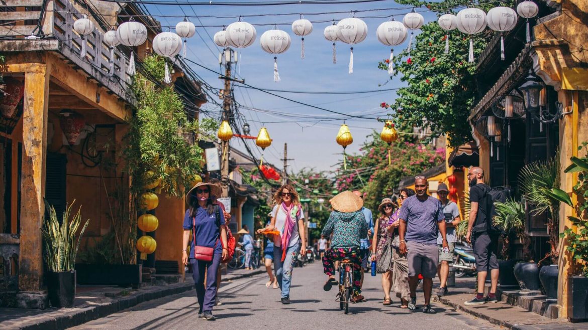 Travellers wandering down a lantern-filled street in Hoi An, Vietnam