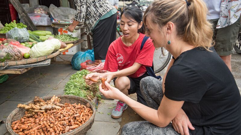 Traveller and local inspecting street food in Vietnam
