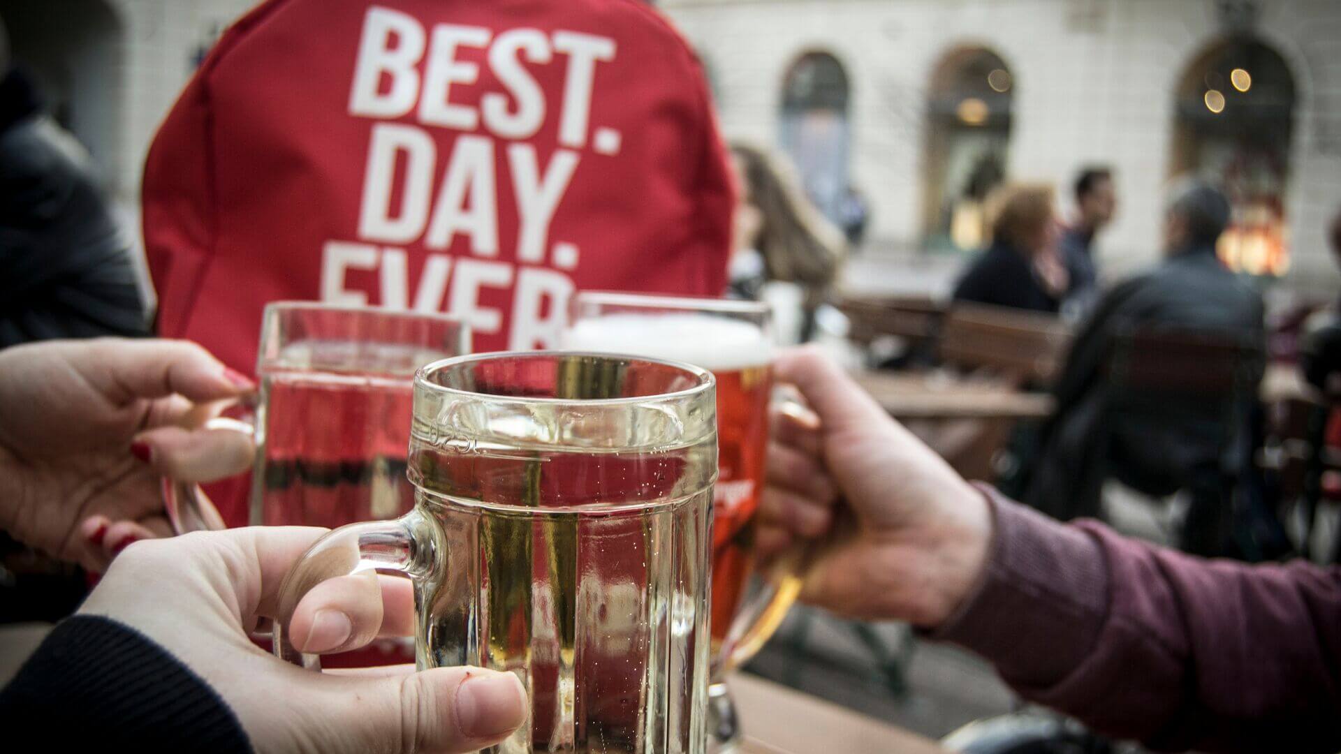 Three people cheers with stein glasses of beer