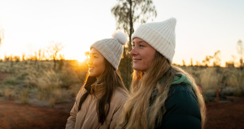 Travellers admiring the sunrise on a chilly winter's morning at Uluru