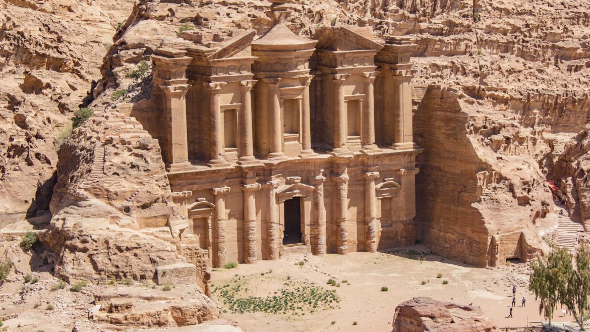 a sandstone coloured building carved into mountain rock