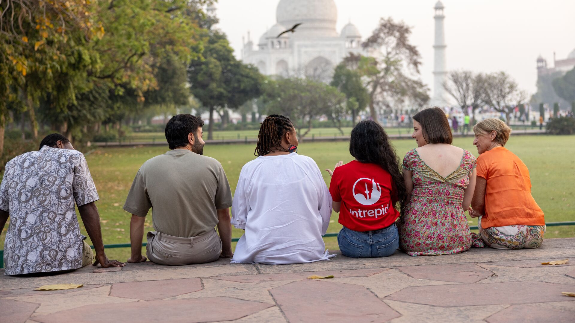 Wadzi and her Intrepid group sit with their local leader admiring the Taj Mahal in Agra, India