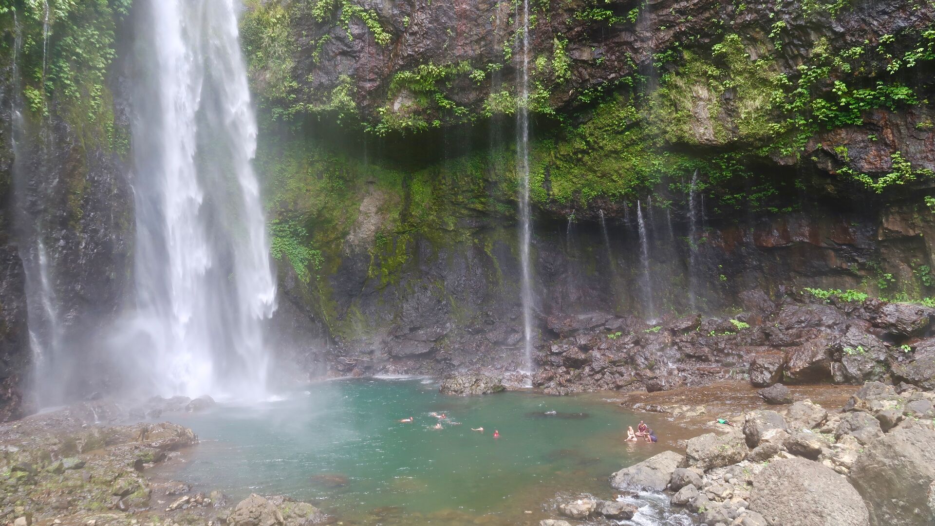 A group of travellers swimming in Nabalesere waterfall, Fiji