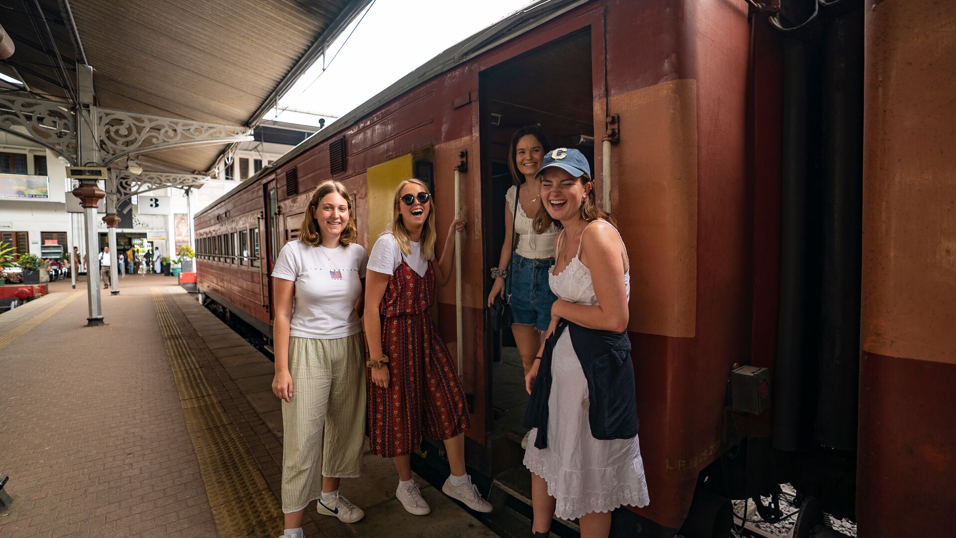 A group of four travellers boarding a train in Sri Lanka