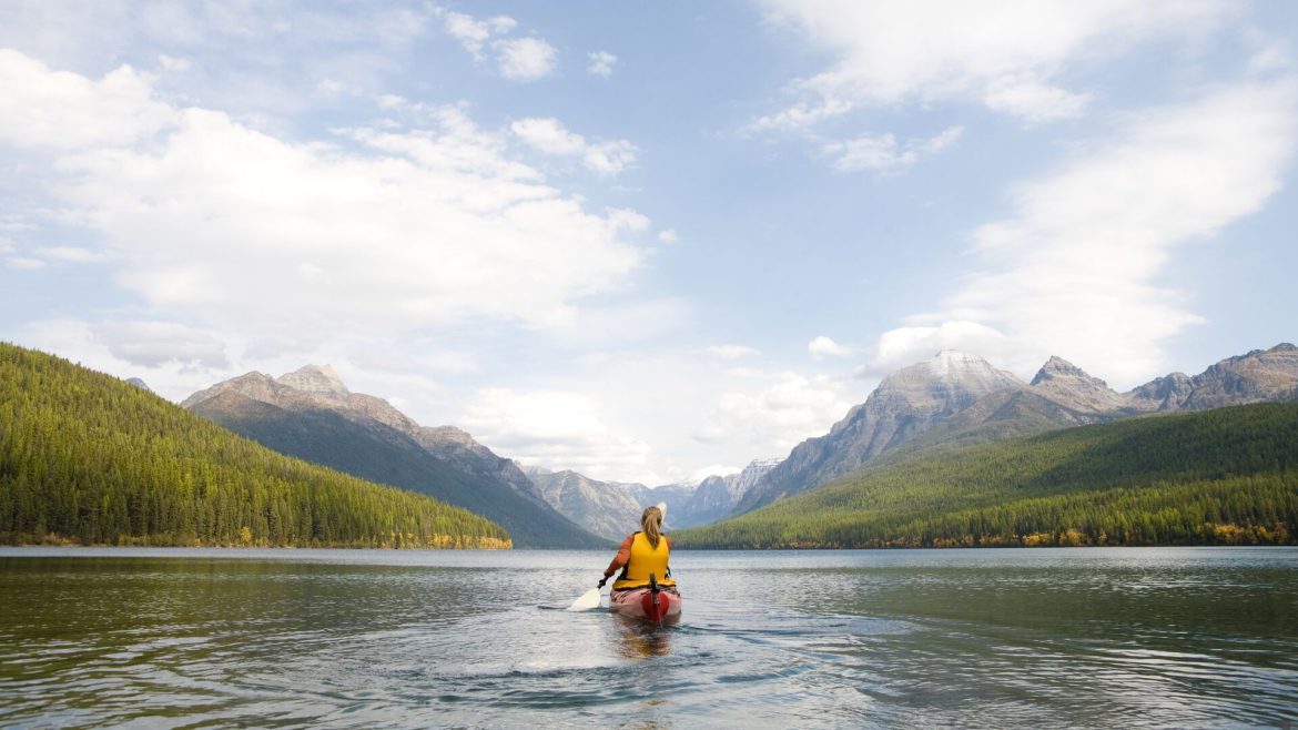 A traveller kayaking on Bowman Lake in Glacier National Park, Montana