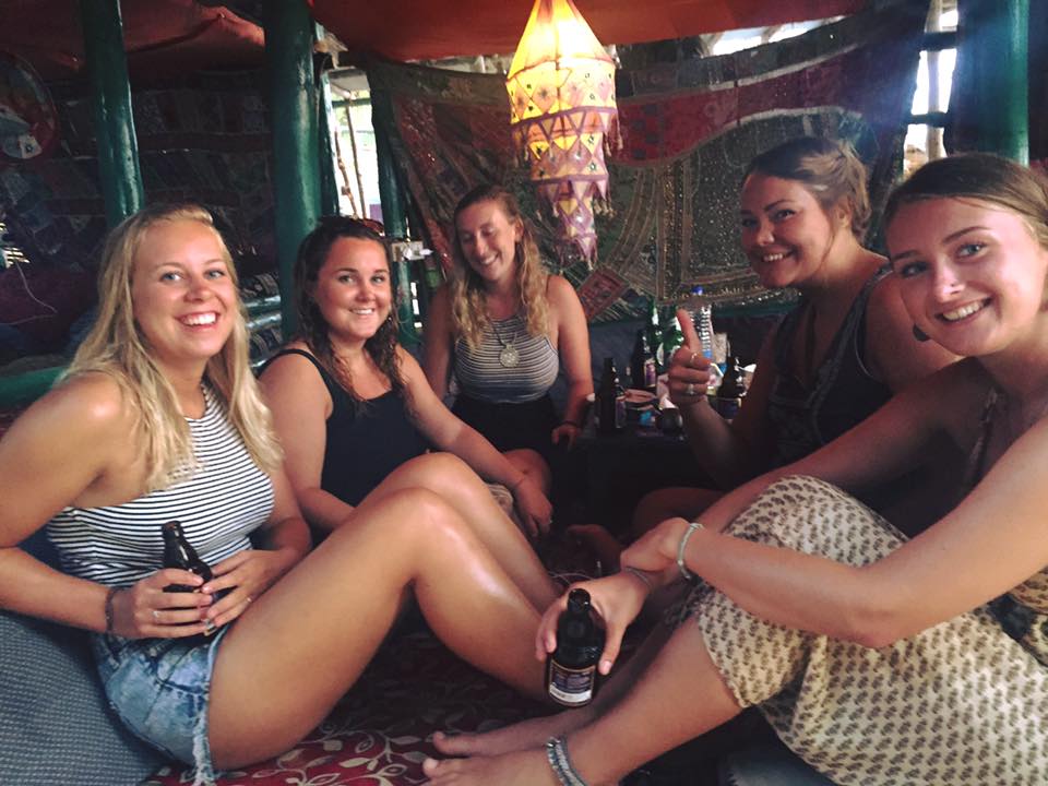 A group of travellers drinking beers at a bar in Goa, India