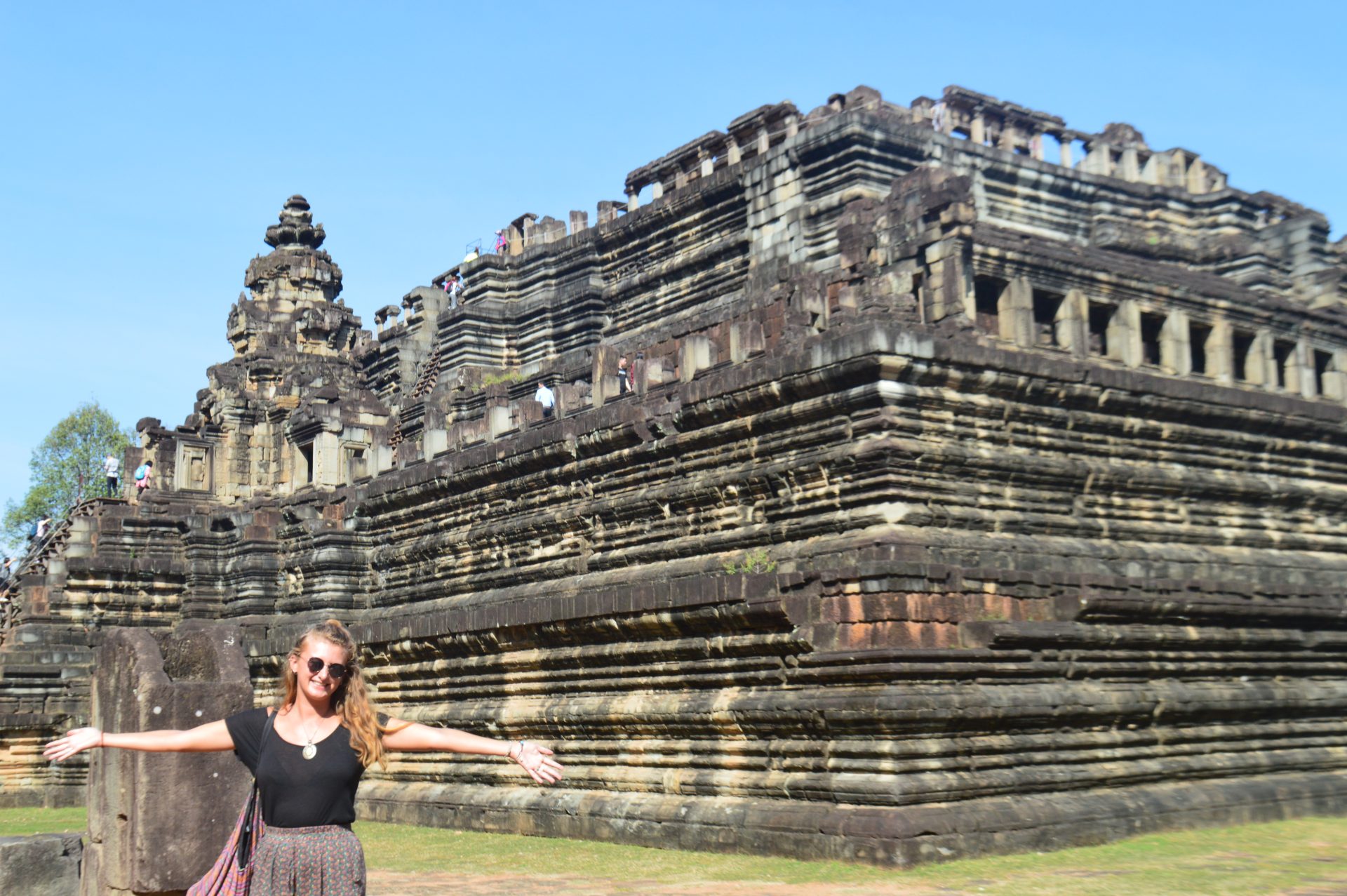 A traveller posing for a photo outside a temple in the Angkor complex in Cambodia