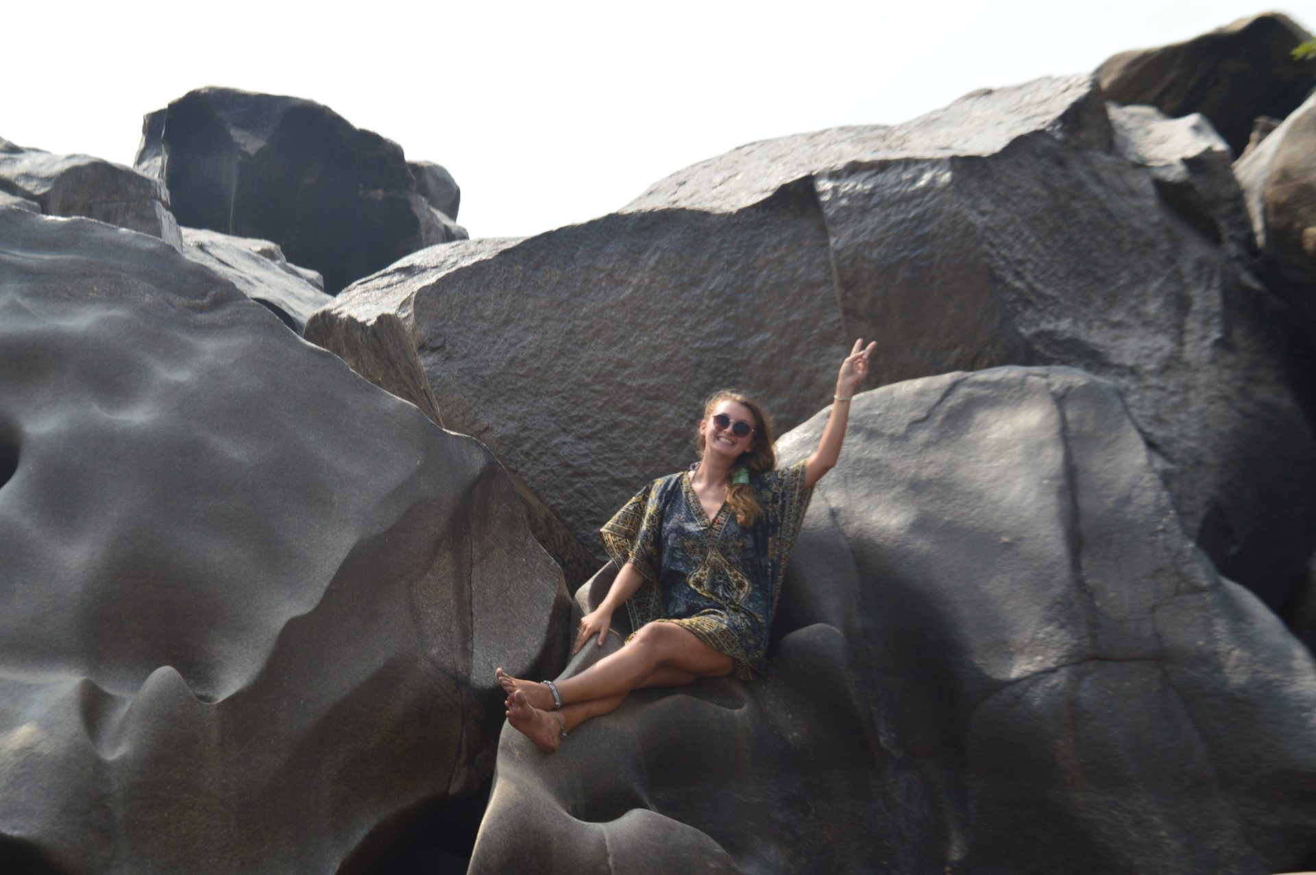 A traveller smiling on rocks near the River Tungabhadra, India