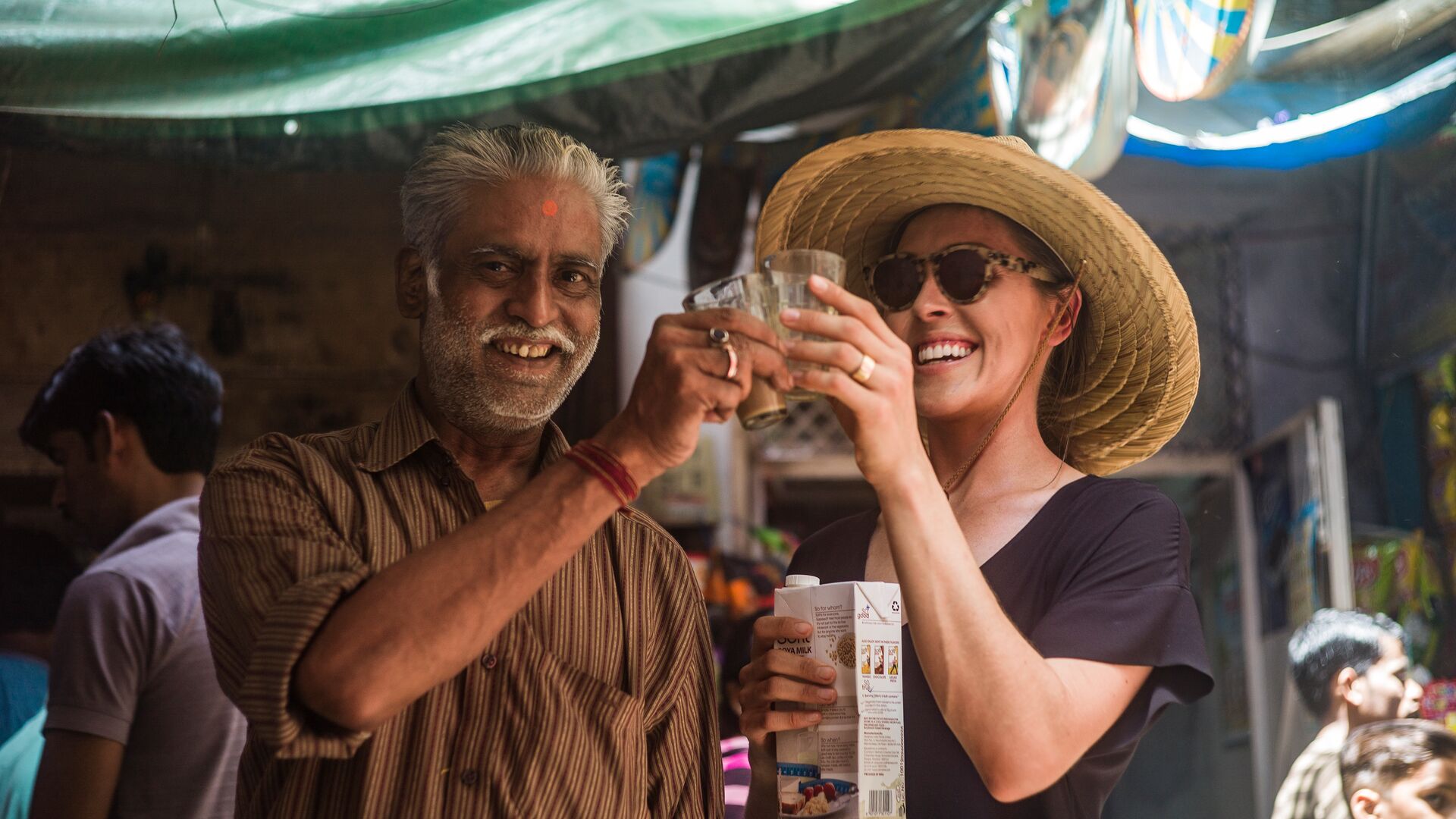 A traveller clinking chai glasses with a chai wallah in India