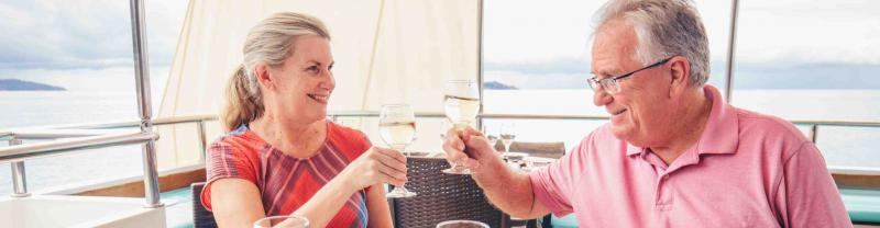 Two Intrepid travellers clink glasses of wine on an Adventure Cruise in Thailand