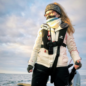 Woman wearing a white jacket staring off into the distance 