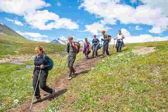 A group of hikers walking down a grassy hill