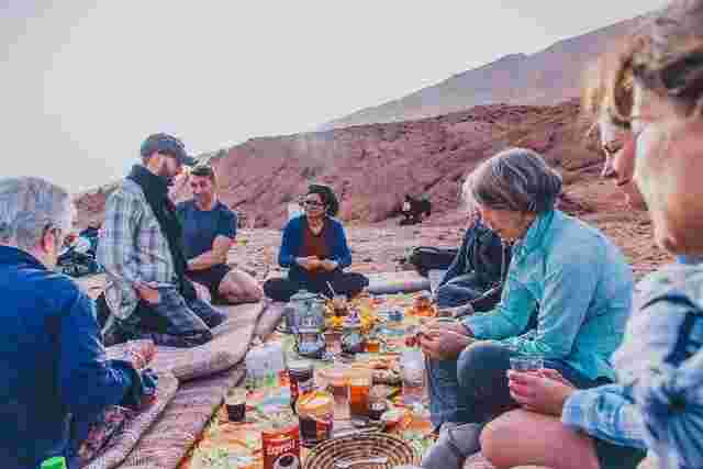 A group of travelers enjoying traditional Moroccan food in a Berber community in Morocco