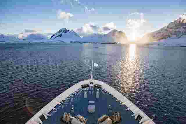 The bow of the Ocean Endeavour as it sails the calm waters of Antarctica at sunset