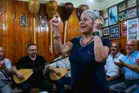 A traveller dancing to a band playing local folk music in Bursa, Turkey