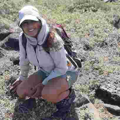 Woman crouching on the ground and smiling at the camera 