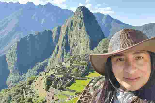 Woman standing in front of the ruins of Machu Pichu 