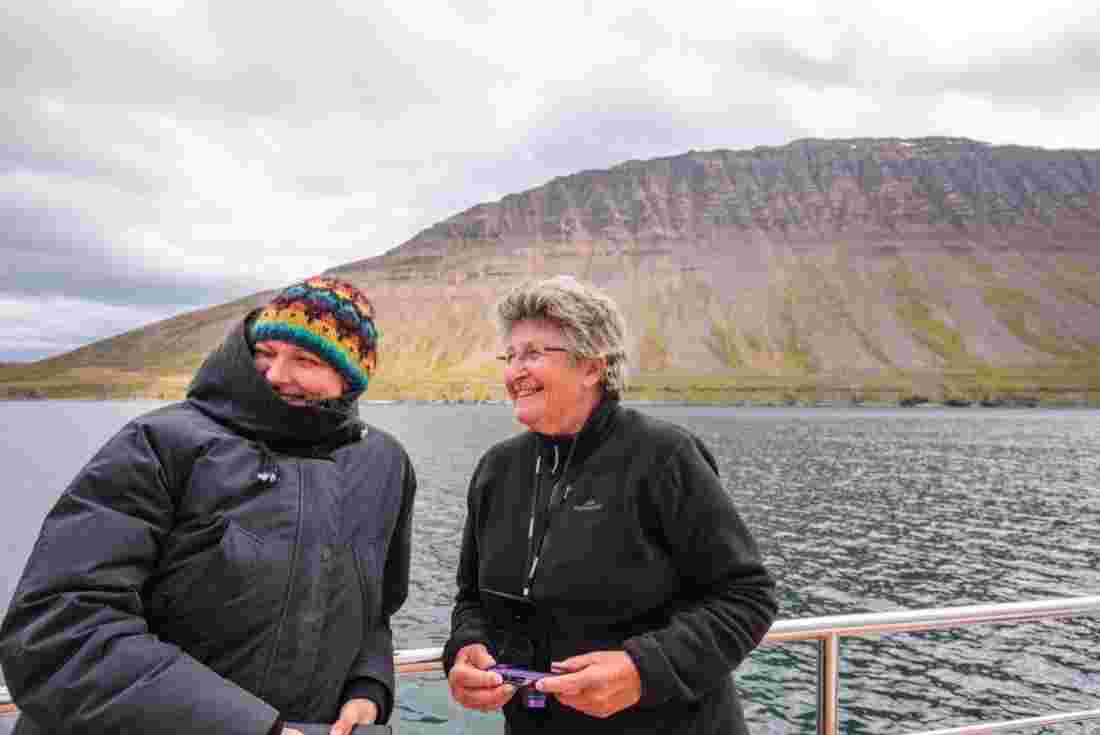 Two older women enjoying a cruise on Siglufjordur in Iceland 