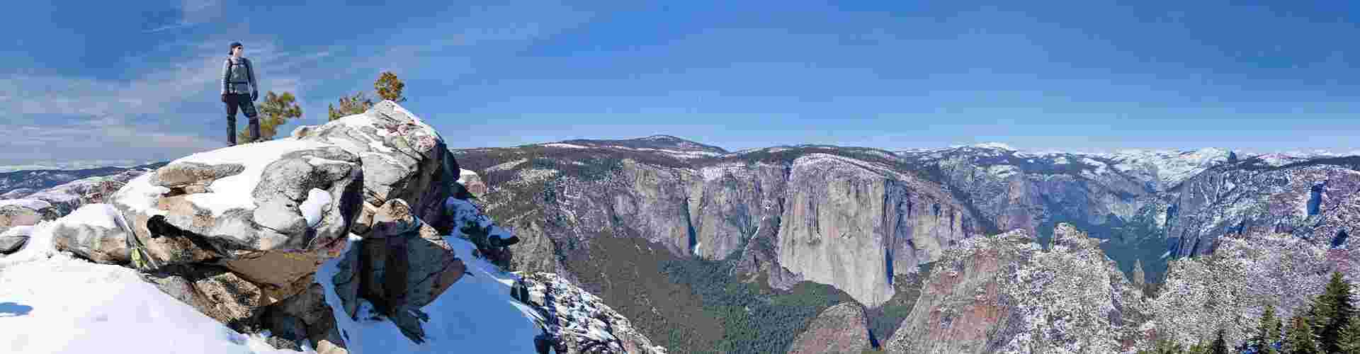 A hiker admiring the views of Yosemite National Park in winter