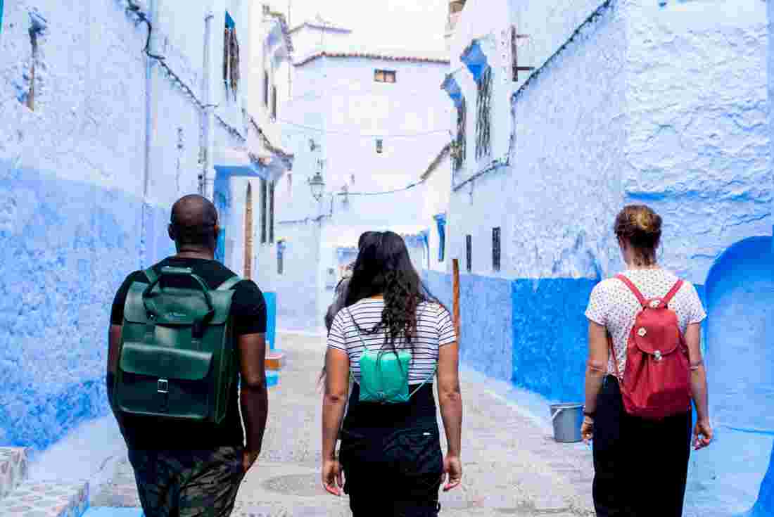 Travellers walking down the blue painted lanes of Chefchaouen