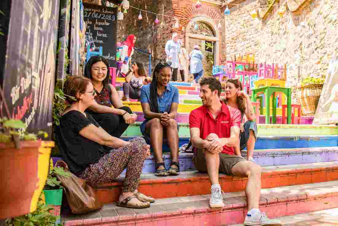 Intrepid leader and group relaxing on stairs in colourful Istanbul