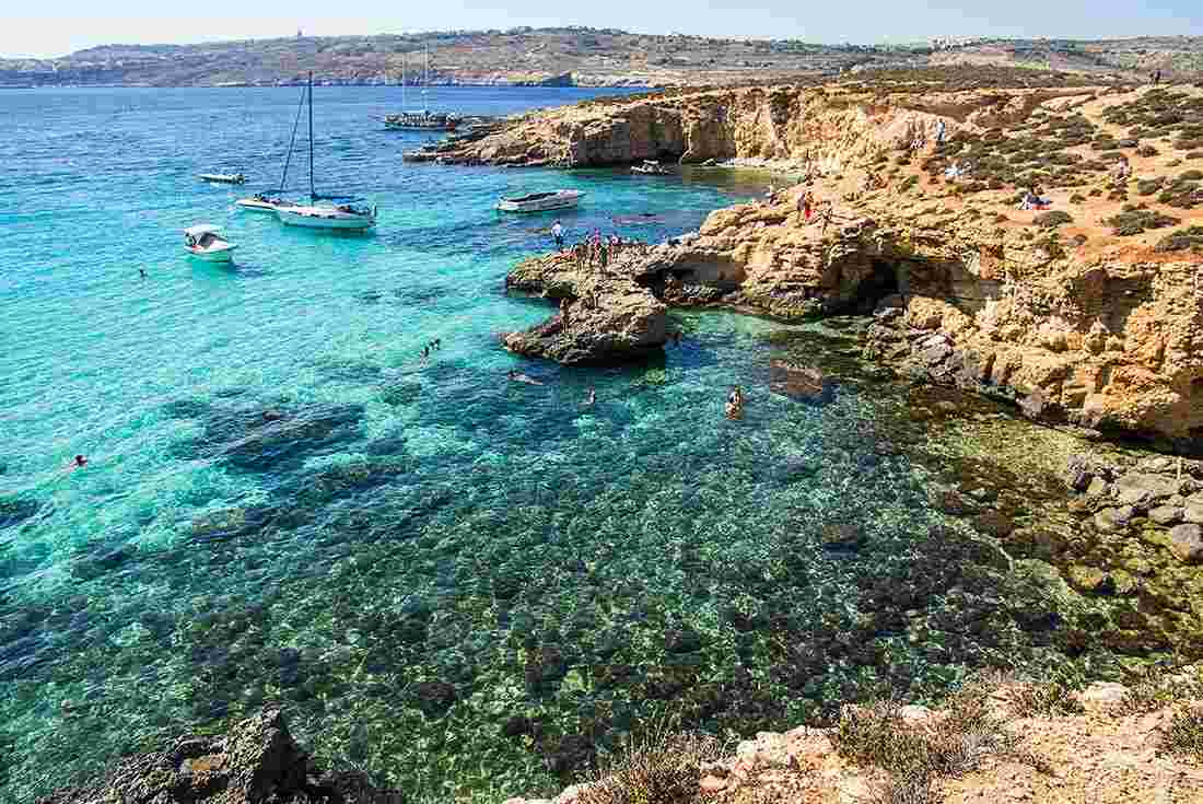 Drone of people in the clear waters of Blue Lagoon, Malta