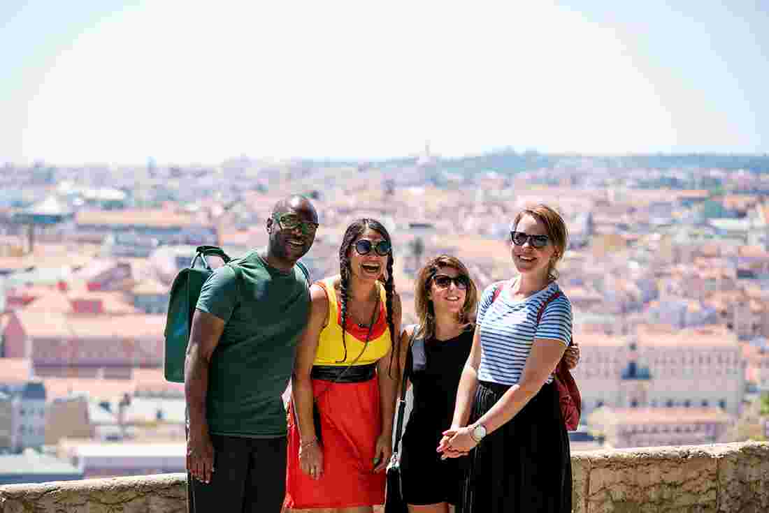 Group of Intrepid travellers laughing with city view in Lisbon, Portugal