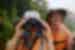Intrepid traveller looks through binoculars for wildlife on the Amazon river in Peru