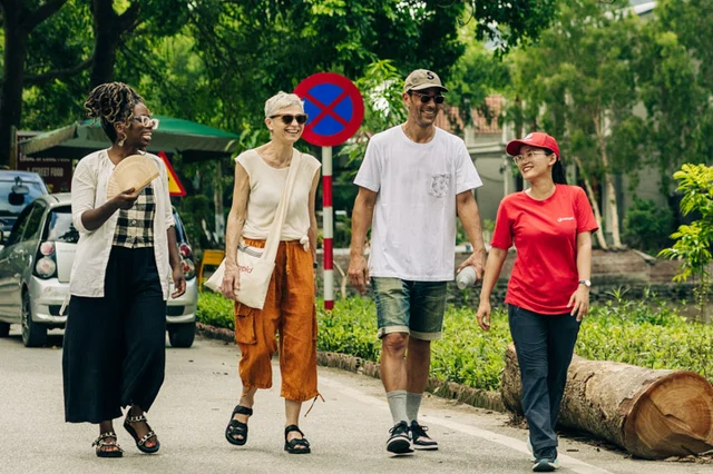 Three travellers and leader walking in Vietnam
