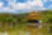 Kinkaku-ji Temple Golden Pavilion at the edge of a curated pond on a sunny day with clouds above