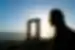 Intrepid traveller looks through the remaining frame of Apollo's Temple Portara at the setting sun on Naxos in the Cyclades