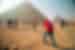 Leader takes a photo of a traveller posing in front of the Pyramids of Giza, Egypt