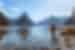 Traveller standing on shore, Milford Sound, Fijordland NP, New Zealand